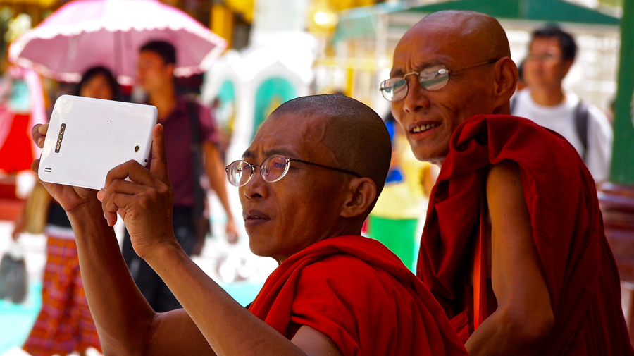 Monk using his phone at the Shwedagon Pagoda in Yangon, Myanmar.