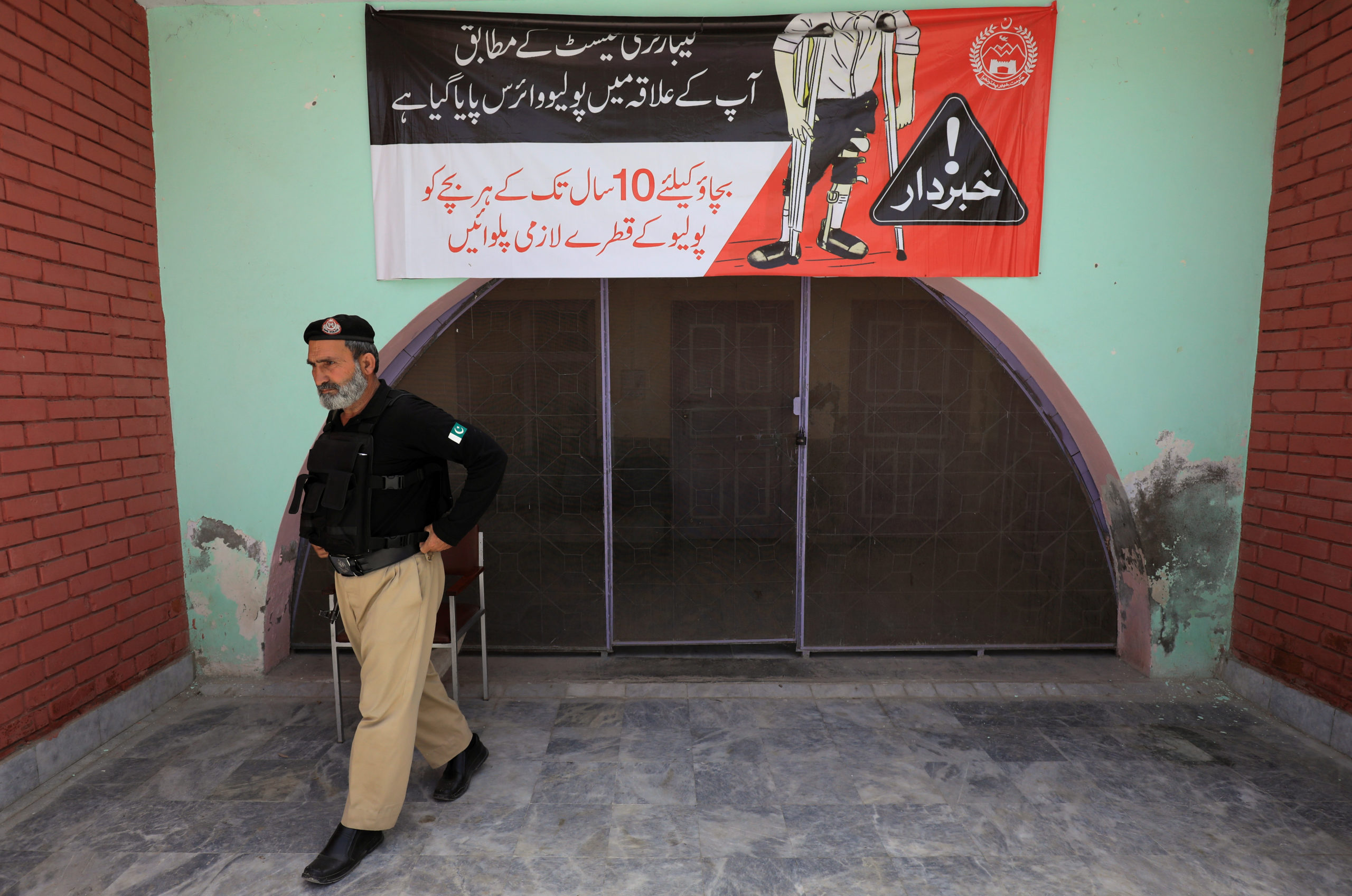 Police officer walks outside a Polio Vaccination centre in Peshawar