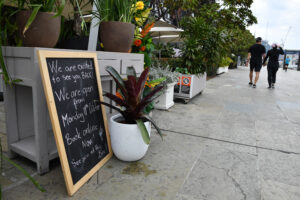 Signage at a business at Barangaroo in Sydney, Saturday, October 9, 2021. Fully vaccinated NSW residents have one day remaining of lockdown, with COVID-19 restrictions set to ease from Monday. (AAP Image/Joel Carrett)