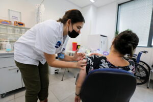 FILE PHOTO: An Israeli woman receives her third dose of the coronavirus disease (COVID-19) vaccine, in Beit Shemesh, Israel October 14, 2021. REUTERS/Ammar Awad/File Photo