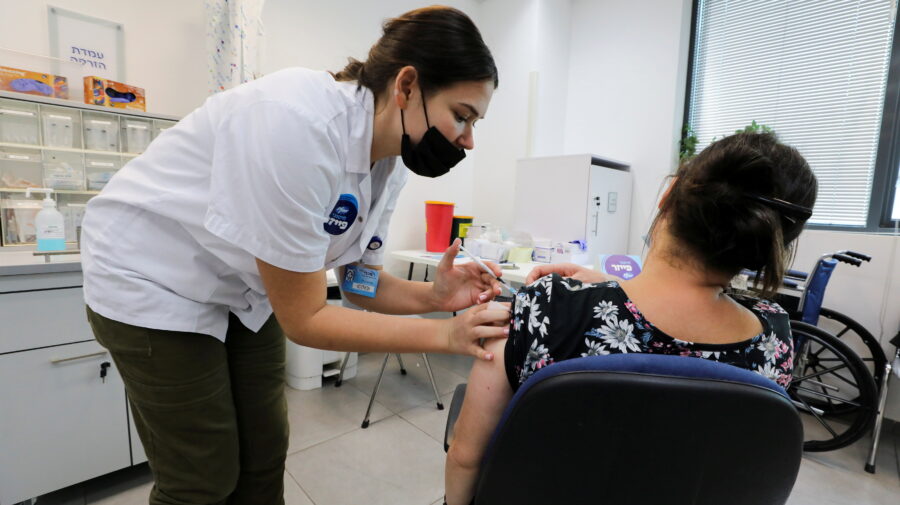 FILE PHOTO: An Israeli woman receives her third dose of the coronavirus disease (COVID-19) vaccine, in Beit Shemesh, Israel October 14, 2021. REUTERS/Ammar Awad/File Photo